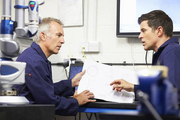 Two employees pointing to a graph and talking.
